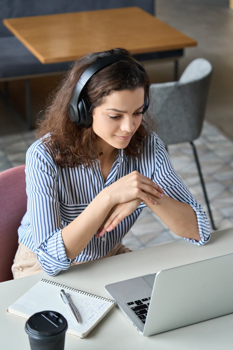 Woman Wearing Headphones and Looking at Laptop